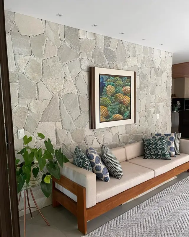 Sala com parede revestida de Pedra Atacama atrás do sofá