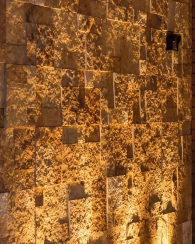 Parede de Murisca Gold dourada iluminada de cima