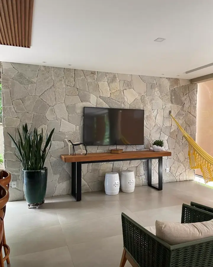 Parede de TV revestida com Pedra Atacama, com aparador de madeira e rede